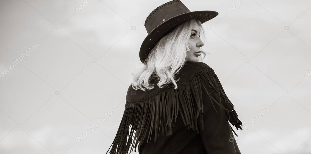 Woman in American country style,  suede leather boho jacket and cowboy hat at nature