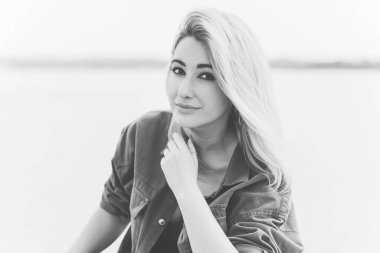 Modern blonde woman mix race in jeans jacket, fashionable details on a model, concept of trend in wardrobe