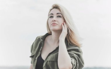 Modern blonde woman mix race in jeans jacket, fashionable details on a model, concept of trend in wardrobe