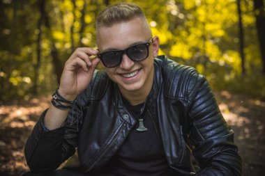 Smiling young handsome stylish student, blonde guy, lifestyle of teen- youth life. Portrait of young man
