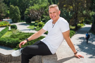 Smiling young handsome stylish student, blonde guy, lifestyle of teen- youth life. Portrait of young man