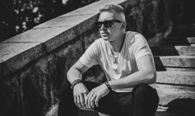 Young stylish Nordic blonde guy, portrait of modern youth. Confident boy with stylish clothes and accessories