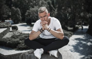 Young stylish Nordic blonde guy, portrait of modern youth. Confident boy with stylish clothes and accessories