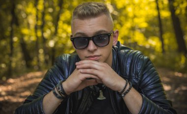 Young stylish Nordic blonde guy, portrait of modern youth. Confident boy with stylish clothes and accessories