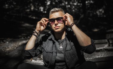 Young stylish Nordic blonde guy, portrait of modern youth. Confident boy with stylish clothes and accessories