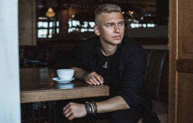 Young stylish Nordic blonde guy, portrait of modern youth. Confident boy with stylish clothes and accessories