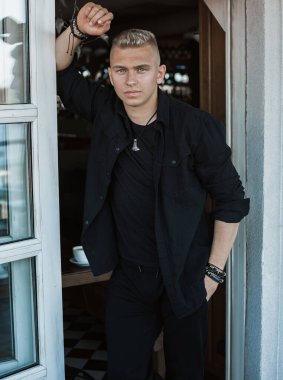 Young stylish Nordic blonde guy, portrait of modern youth. Confident boy with stylish clothes and accessories