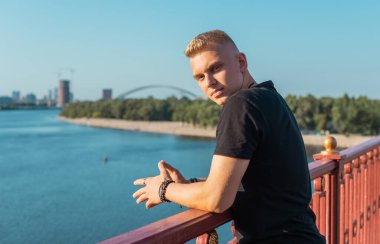 Young stylish Nordic blonde guy, portrait of modern youth. Confident boy with stylish clothes and accessories