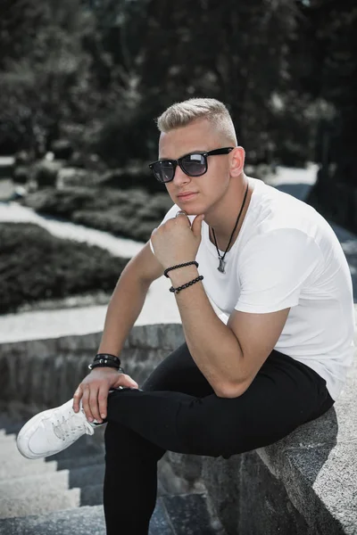 Young stylish Nordic blonde guy, portrait of modern youth. Confident boy with stylish clothes and accessories
