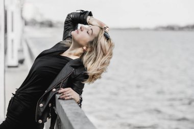 A young woman in leather jacket. Concept of grunge style 90x, mix clothes, outfits for women