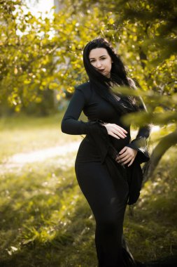 Siyah elbiseli güzel ve gizemli cadı kadın. Cadılar Bayramı, sihirli zaman