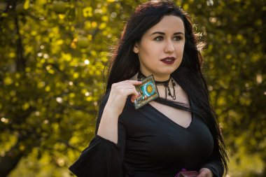 Siyah elbiseli güzel ve gizemli cadı kadın. Cadılar Bayramı, sihirli zaman