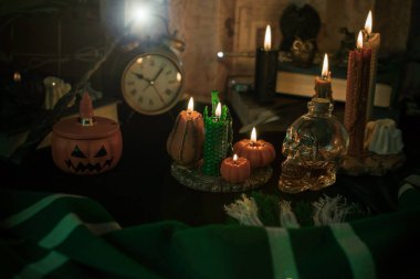 Sihirli şeylerin tasviri... mum ışığı, sihirli değnek, büyü kitabı karanlık arka plan, büyücülük okulu, yeşil estetik, Cadılar Bayramı zamanı