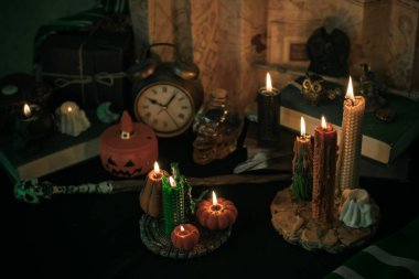 Sihirli şeylerin tasviri... mum ışığı, sihirli değnek, büyü kitabı karanlık arka plan, büyücülük okulu, yeşil estetik, Cadılar Bayramı zamanı