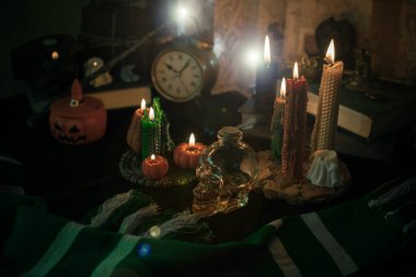 Sihirli şeylerin tasviri... mum ışığı, sihirli değnek, büyü kitabı karanlık arka plan, büyücülük okulu, yeşil estetik, Cadılar Bayramı zamanı