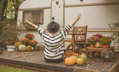Sonbahar bahçesinde Boho tarzı giyinmiş, felsefi bir havası olan zarif sarışın bir kadın. Güzel aksesuarlı ve doğal bir tarzı olan bir bayan.
