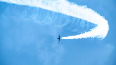Uçak havada beyaz bir döngü iziyle bir gösteri sergiliyor..