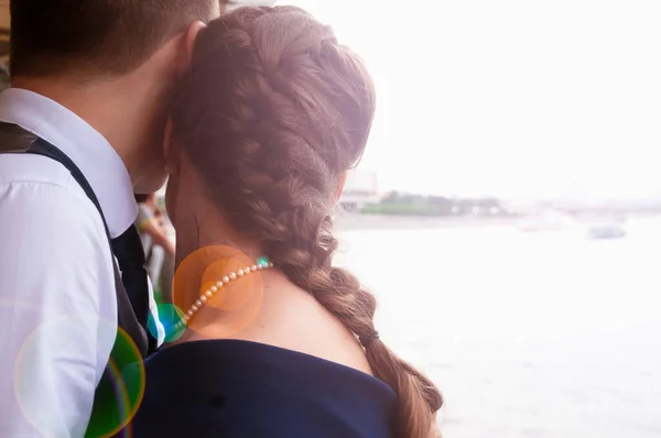 A couple in love looks into the distance into a bright future huddled together on a ferry
