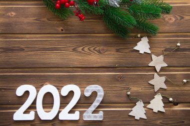 Mutlu yıllar 2022. Tahta Noel ya da yeni yıl süslemeleri. Beyaz numaraları 2022 olan Noel arkaplanı
