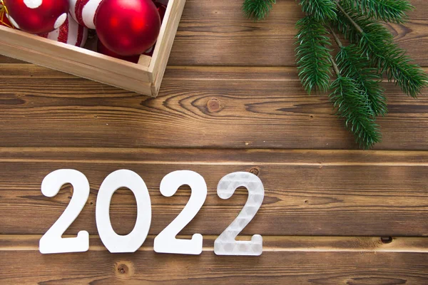 Mutlu yıllar 2022. Tahta Noel ya da yeni yıl süslemeleri. Beyaz numaraları 2022 olan Noel arkaplanı