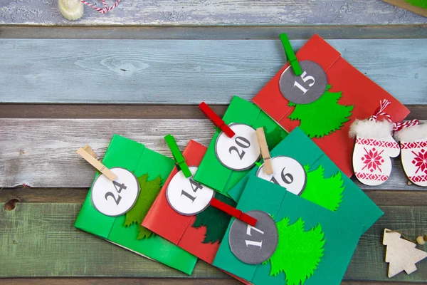 Masada, ahşap bir kutuda Noel takvimi var. El yapımı çok renkli zarflar.