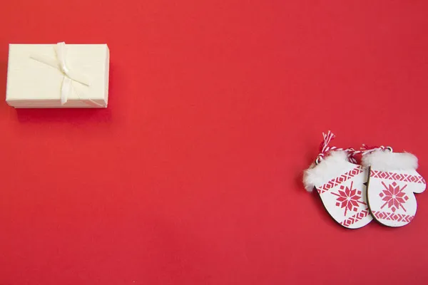 Kırmızı arka planda yeni yıl planı, eldivenler, kızak, ahşap yeni yıl treni, ahşap Noel ağaçları. 2022