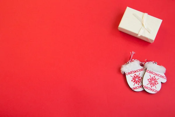 Kırmızı arka planda yeni yıl planı, eldivenler, kızak, ahşap yeni yıl treni, ahşap Noel ağaçları. 2022