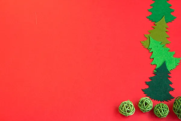 Kırmızı arka planda yeni yıl planı, eldivenler, kızak, ahşap yeni yıl treni, ahşap Noel ağaçları. 2022