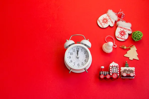 Kırmızı arka planda yeni yıl planı, eldivenler, kızak, ahşap yeni yıl treni, ahşap Noel ağaçları. 2022