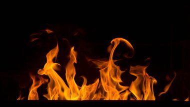 Siyah arka planda parlak turuncu şenlik ateşi. Soyut ateş dokusu. Ateşin gerçekçi alevi hareket çerçevesini yakar. Tasarım için doku. Ateşin dokusu. Alevli bir şenlik ateşi.