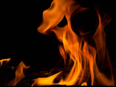 Siyah arka planda parlak turuncu şenlik ateşi. Soyut ateş dokusu. Ateşin gerçekçi alevi hareket çerçevesini yakar. Tasarım için doku. Ateşin dokusu. Alevli bir şenlik ateşi.
