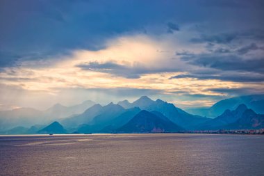Dağlarda gün batımı. Türkiye 'nin Antalya kentindeki mavi tepeler üzerinde dramatik renkli bulutlar. Misty Hills dağları. Mavi tonda güzel bir dağ manzarası.