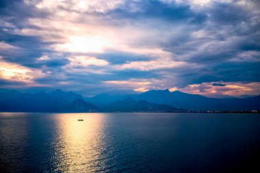 Dağlarda gün batımı. Türkiye 'nin Antalya kentindeki mavi tepeler üzerinde dramatik renkli bulutlar. Misty Hills dağları. Mavi tonda güzel bir dağ manzarası.