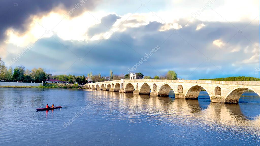 Those who canoe in the Meric river in Edirne. Canoeists passing under the Mecidiye Bridge. Blue sky and peaceful times.