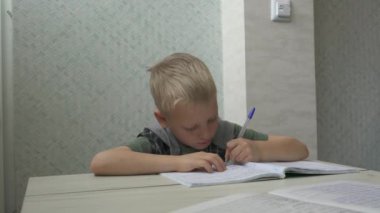 Portre okulu çocuğu masada oturuyor, ödev yapıyor, evde eğitim görüyor.