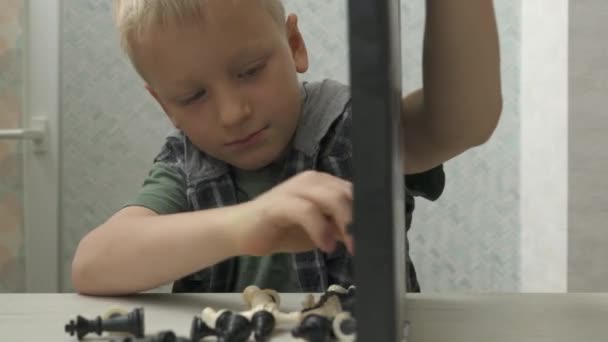 Netter kleiner Junge spielt zu Hause Schach. — Stockvideo