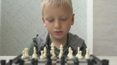 Evde satranç oynayan sevimli küçük çocuk..