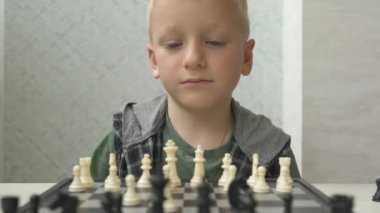 Evde satranç oynayan sevimli küçük çocuk..