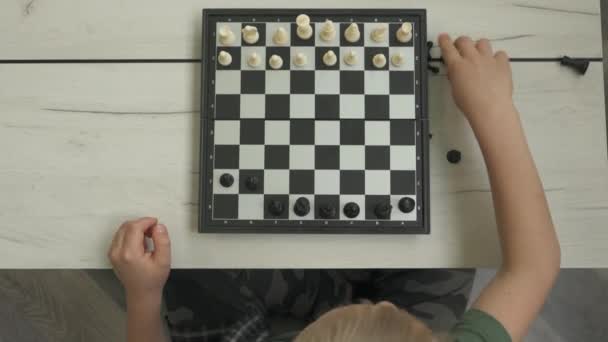 Söt liten pojke spelar schack hemma. — Stockvideo