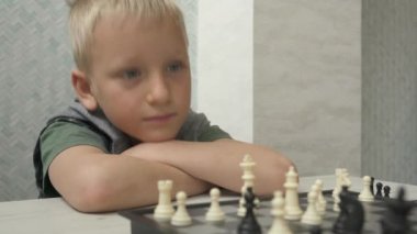 Erkek ve kız kardeş evde satranç oynuyor.