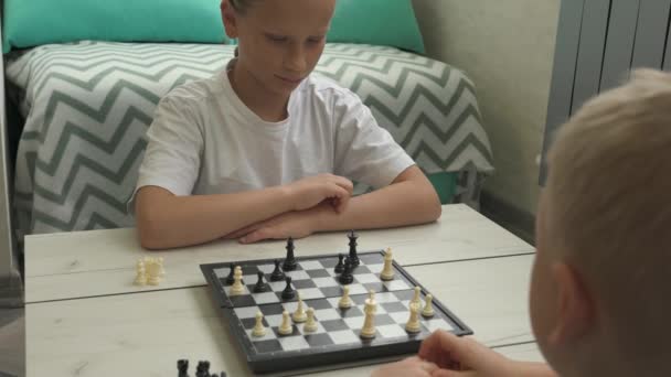 Erkek ve kız kardeş evde satranç oynuyor. — Stok video