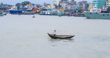 Dhaka 'daki Buriganga nehri üzerindeki Sadarghat nehir limanının güzel manzarası. Nehirde bulutlu bir arka planı olan feribotlar..
