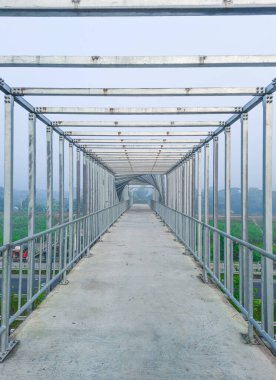 Köprünün üzerindeki eşsiz iç mekan. Güzel ayak köprünün üzerinde sabah bulanık bir fotoğrafta. Çelik köprü.