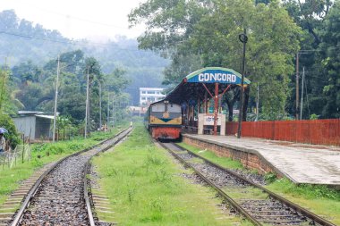 İnsanlar yağmurda tren için bekliyor. Yağmurlu bir tren istasyonu. Chittagong Üniversitesi, Bangladeş tren istasyonu.