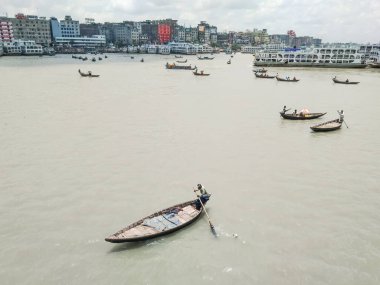 Dhaka 'daki Buriganga nehri üzerindeki Sadarghat nehir limanının güzel manzarası. Nehirde bulutlu bir arka planı olan feribotlar..
