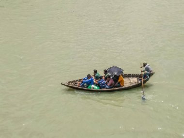 Dhaka 'daki Buriganga nehri üzerindeki Sadarghat nehir limanının güzel manzarası. Nehirde bulutlu bir arka planı olan feribotlar..