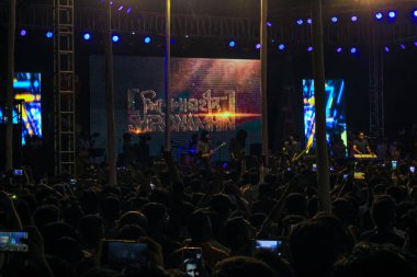 Grubun çaldığı her şarkının tadını çıkarıyorum. Bir müzik konserinde büyük bir kalabalığın fotoğrafını çektim. Gitaristler ve Davulcu 'nun konserde çaldığı rock grubu. Bangladeşli grup Shironamhin konseri.