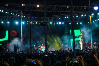 Grubun çaldığı her şarkının tadını çıkarıyorum. Bir müzik konserinde büyük bir kalabalığın fotoğrafını çektim. Gitaristler ve Davulcu 'nun konserde çaldığı rock grubu. Bangladeşli grup Shironamhin konseri.