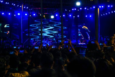 Grubun çaldığı her şarkının tadını çıkarıyorum. Bir müzik konserinde büyük bir kalabalığın fotoğrafını çektim. Gitaristler ve Davulcu 'nun konserde çaldığı rock grubu. Bangladeşli grup Shironamhin konseri.