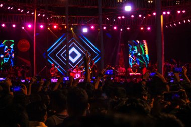 Grubun çaldığı her şarkının tadını çıkarıyorum. Bir müzik konserinde büyük bir kalabalığın fotoğrafını çektim. Gitaristler ve Davulcu 'nun konserde çaldığı rock grubu. Bangladeşli grup Shironamhin konseri.